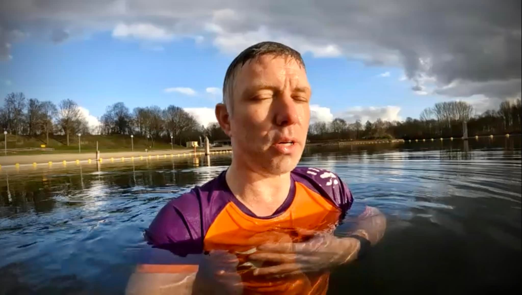Rolf, zwemmend in open water met een oranje zwemvest om